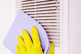 A picture of a hand cleaning an air filter cover.