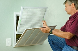 An Aire Serv technician replacing an air filter.