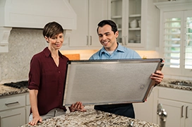 An Aire Serv technician showing an air filter to a customer.