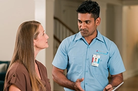 Aire Serv tech meeting indoors with customer to discuss system.