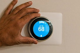 Hand moving a programmable thermostat.