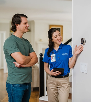 Female ASV tech showing customer thermostat.