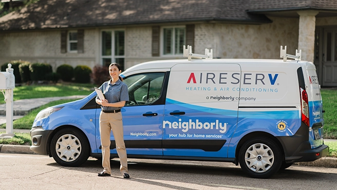 An asv technician standing beside a van.