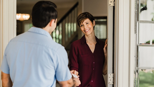 An asv technician giving card to client.