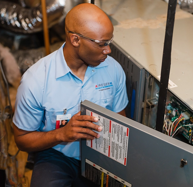 Aire Serv technician repairing furnace.