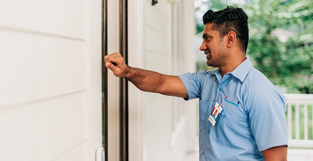 ASV technician knocking on the door at the service location.