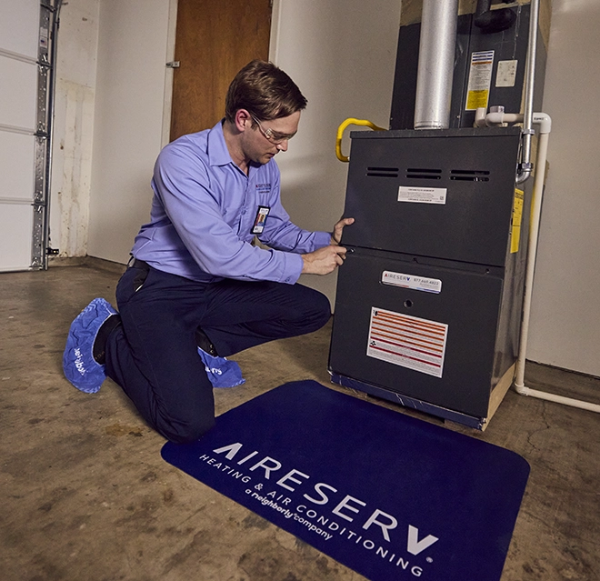 ASV technician working on the furnace in the garage.