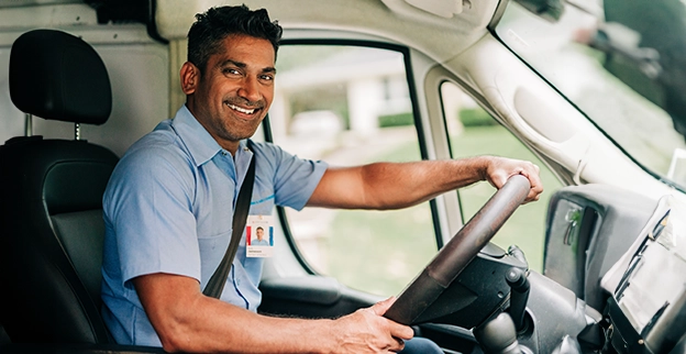 Smiling AireServ technician sitting in vehicle.
