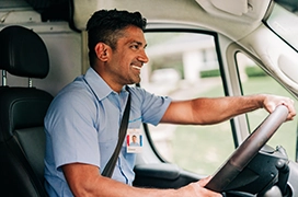 Smiling Aire Serv technician driving vehicle.