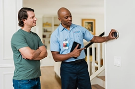 AireServ tech explaining thermostat to customer.