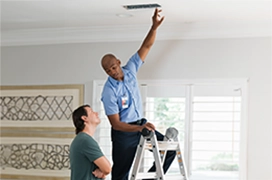 Aire Serv tech showing clean ceiling air vent to customer.