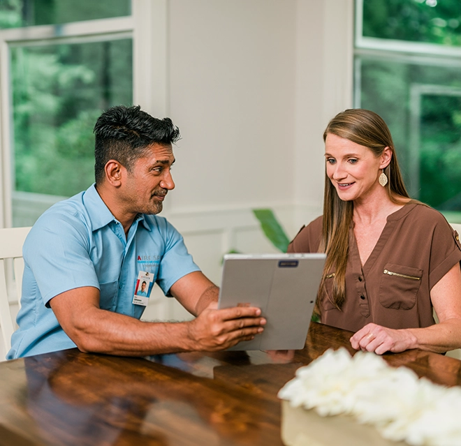 ASV Client and worker speaking at a table while reviewing work order.