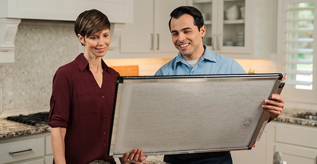 Aire Serv technician shows a customer a new air filter.