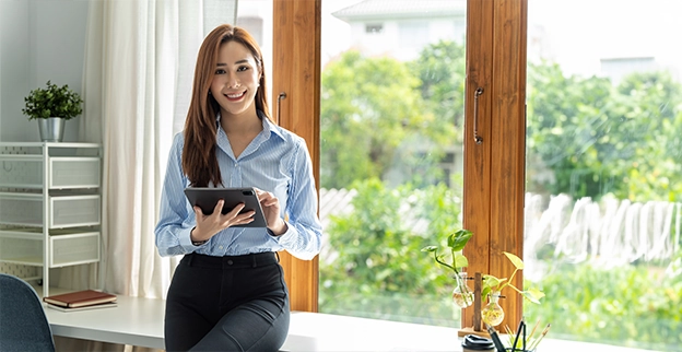 Aire Serv technician smiling while holding a tablet device.