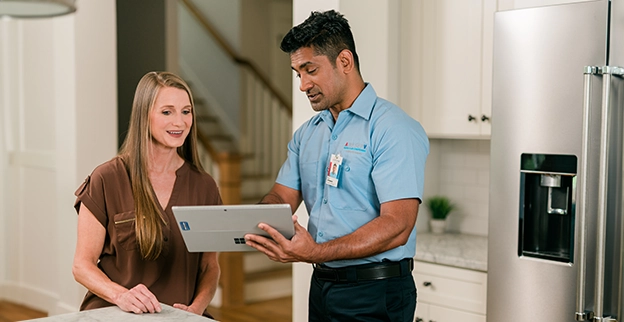 Aire Serv technician showing a customer something on their tablet device.