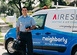 Aire Serv technician standing beside the side of an Aire Serv van.
