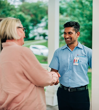 Aire Serv tech shaking hands with female customer.