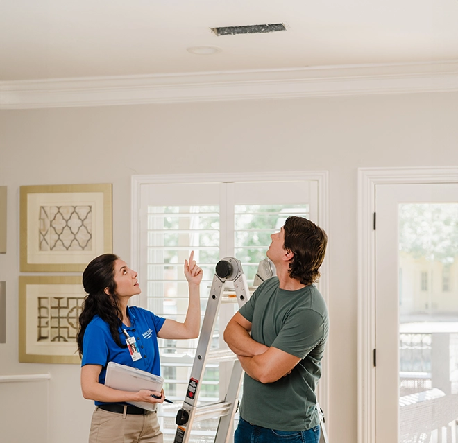 Aire Serv technician showing a customer their air vent.