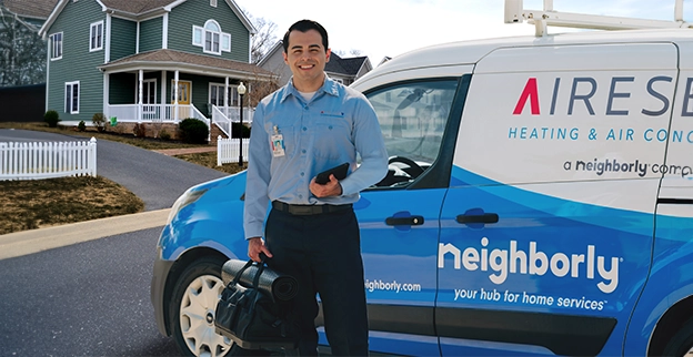 Aire Serv technician standing in front of an Aire Serv van.