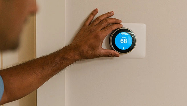 Aire Serv technician working on a customer's thermostat.