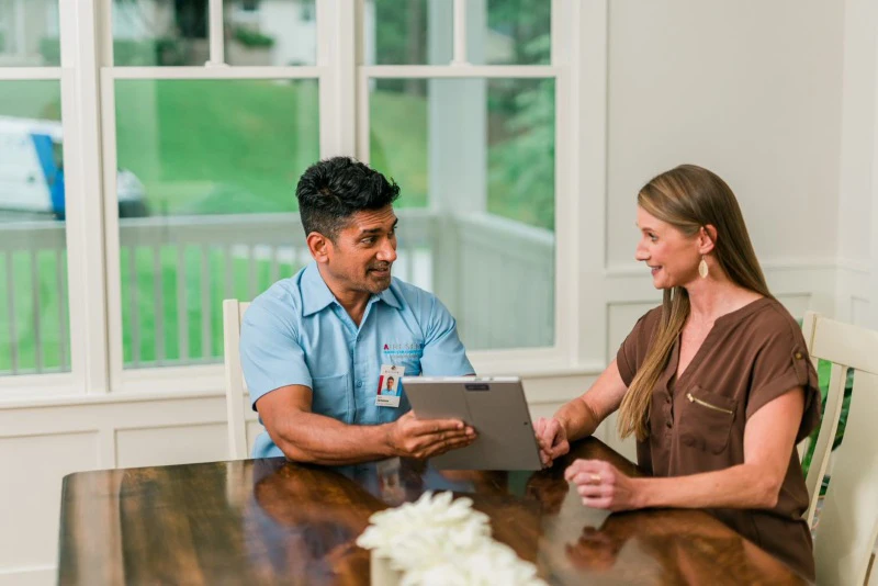 Aire Serv tech discussing humidifier repair service with customer.