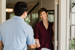 An Aire Serv professional handing over business card to customer.