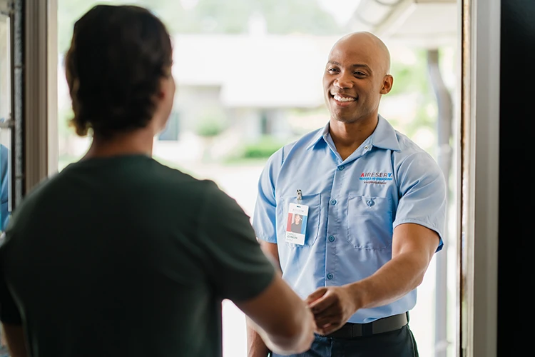 Aire Serv HVAC specialist greeting customer before ductless heat pump service