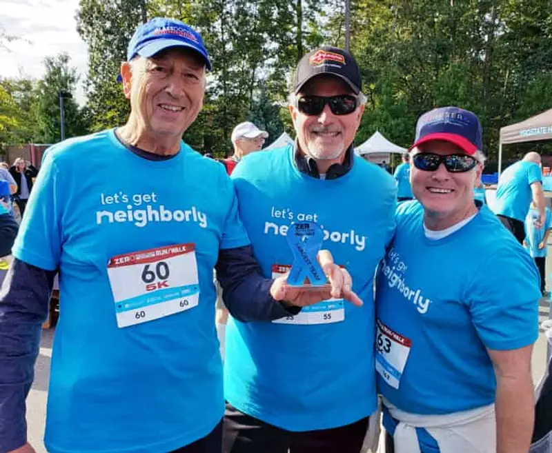 3 people in blue shirts smiling