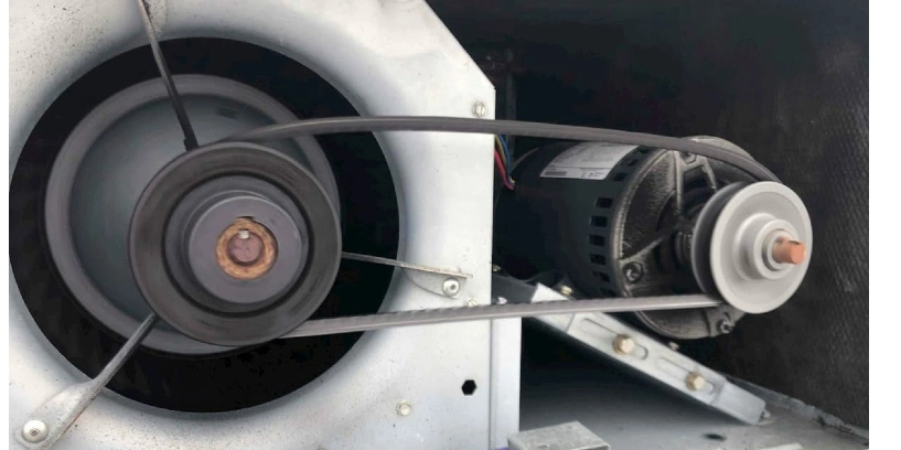 Close-up of air conditioning unit's exposed fan belt.