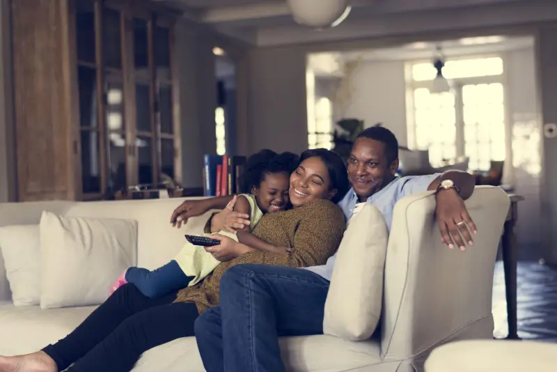 Family relaxing on the couch of a residential home.