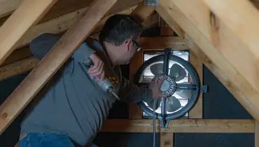 Man installing attic fan