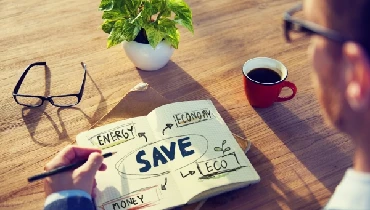 Man looking at a diagram in a notebook that highlights energy savings