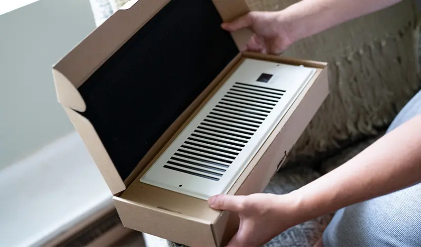 Person opening box containing a new duct vent