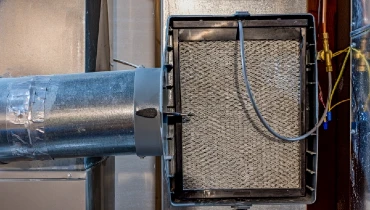 Open whole house humidifier with trickling filter pad and damper exposed