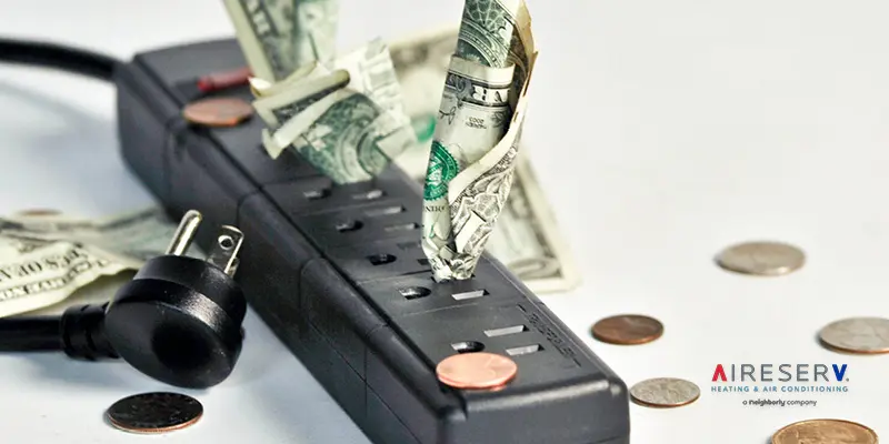 Dollar bills stuffed in black power strip