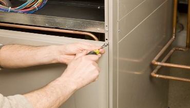 Repair Technician Removing Furnace Service Panel | Aire Serv of Central Illinois