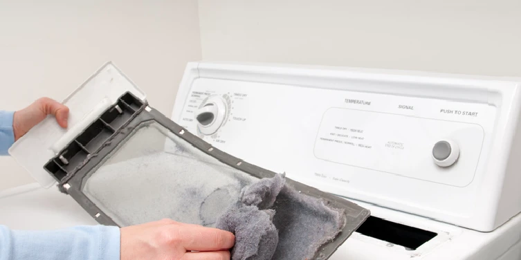 A man removes lint from his clothes dryer&rsquo;s lint trap. | Aire Serv of North Central Arizona