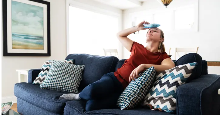 Woman cooling herself down with an ice pack on her head.