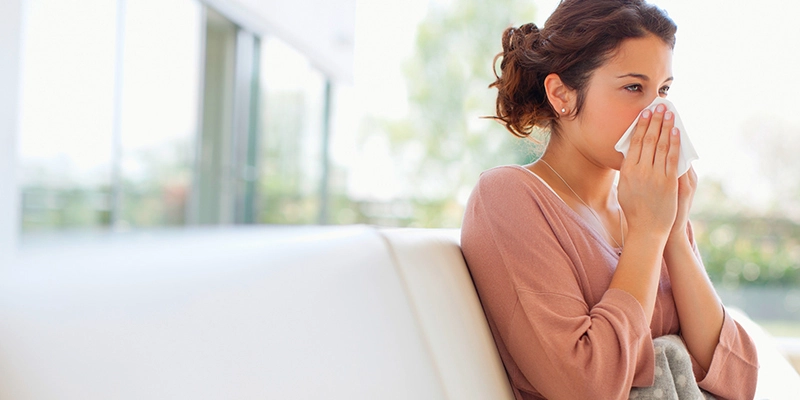 Woman wiping her nose with tissue